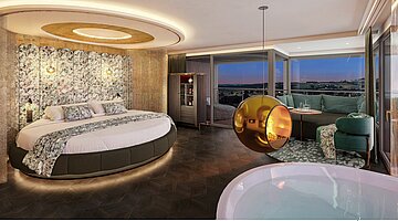 Innenansicht der Hideaway Suite mit Fokus auf das runde Bett mit gemustertem Kopfteil und indirekter Beleuchtung. Im Vordergrund ist der Whirlpool zu sehen, darüber schwebt ein goldener Design-Kamin. Große Fensterfronten bieten einen weiten Blick in die Landschaft.