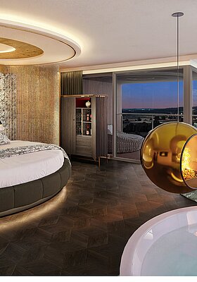 Innenansicht der Hideaway Suite mit Fokus auf das runde Bett mit gemustertem Kopfteil und indirekter Beleuchtung. Im Vordergrund ist der Whirlpool zu sehen, darüber schwebt ein goldener Design-Kamin. Große Fensterfronten bieten einen weiten Blick in die Landschaft.