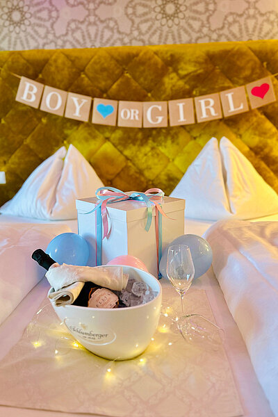 Ein Gender-Reveal Arrangement auf einem Bett im Hotel Winzer