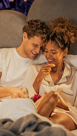 Pärchen mit Frühstück im Bett im Doppelzimmer Spa Deluxe im Hotel Winzer