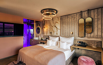 A cosy bed in the stylish Spa double room at Hotel Winzer