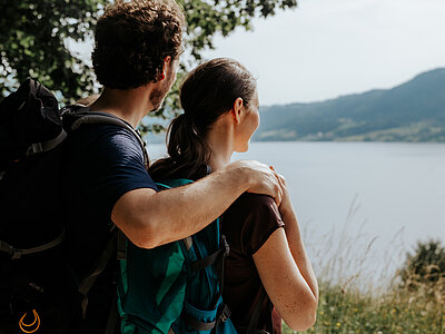 Paar genießt beim Wandern den Ausblick auf den Attersee