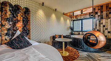 Schlafbereich der Private Cinema Suite Schlafbereich der Private Cinema Suite im Hotel Winzer mit rundem Doppelbett, Designkamin und gemütlicher Sitzecke