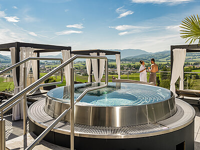 A couple enjoying the hot tub on the sun deck at the Hotel Winzer