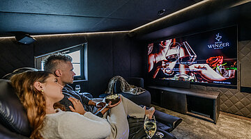 Private Cinema für zwei Private Cinema der Private Cinema Suite im Hotel Winzer mit großem Bildschirm und bequemen Kinosesseln für entspannte Filmabende zu zweit