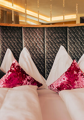 Gemütliches Bett mit Kissen in der Kuschelsuite im Hotel Winzer