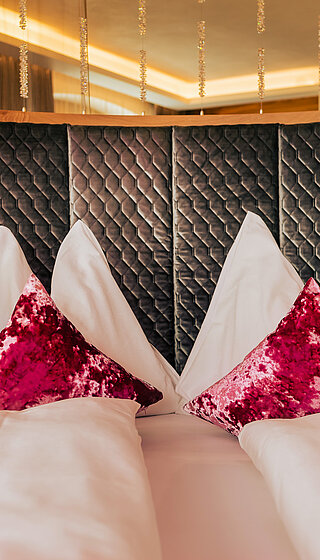 Gemütliches Bett mit Kissen in der Kuschelsuite im Hotel Winzer