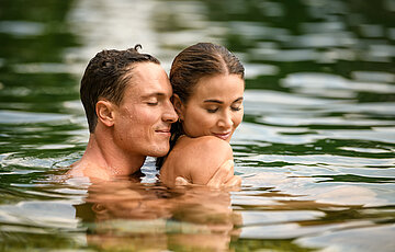 A couple in the natural pool at the Wellnesshotel Winzer