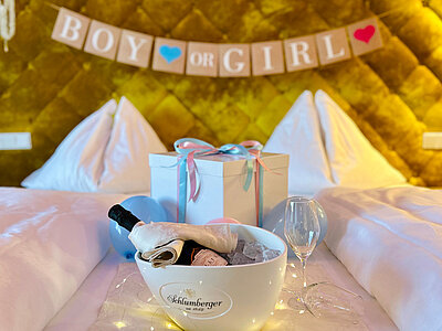 Ein Gender-Reveal Arrangement auf einem Bett im Hotel Winzer