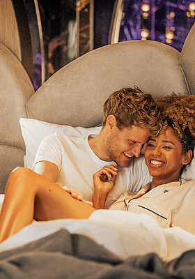 Pärchen entspannt im Bett im Doppelzimmer Spa Deluxe im Hotel Winzer