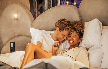 Pärchen entspannt im Bett im Doppelzimmer Spa Deluxe im Hotel Winzer
