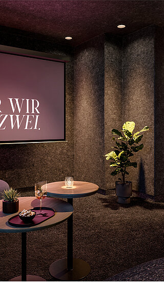 Privater Kinoraum in der Suite mit Leinwand, gemütlichem Sesseln und Blick in ein schimmerndes Badezimmer.