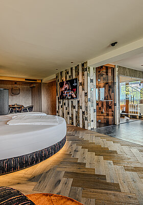 Großzügige Wolke 7 im Hotel Winzer mit rundem Doppelbett, Private Spa, Designkamin und viel Raum für Zweisamkeit