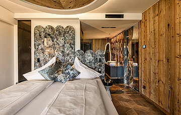 Stylish sleeping area in the Kuschelnest Junior Suite at Hotel Winzer with double bed, natural wood and refined interior design