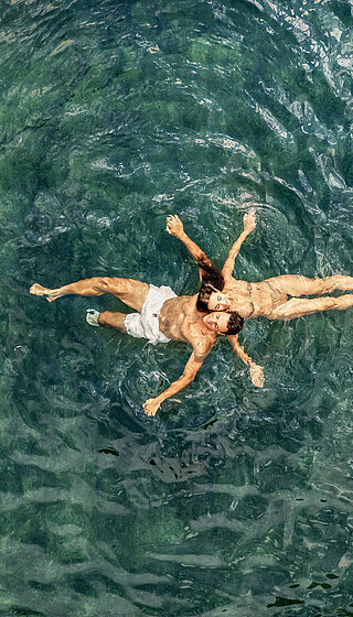 Paar im Wasser des Naturpools im Wellnesshotel Winzer