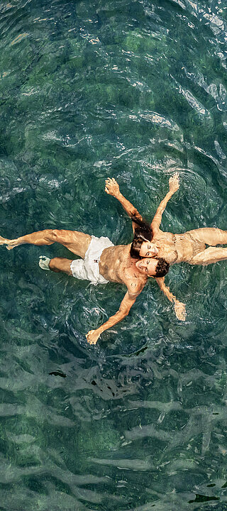 Paar im Wasser des Naturpools im Wellnesshotel Winzer
