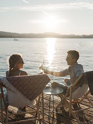 Paar genießt den Sonnenuntergang am Attersee im Salzkammergut