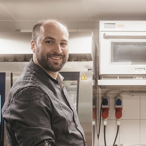 Ein Handgriff hier. Eine geschwungene Pfanne dort. Ein Lächeln, das man sogar durch den Küchendampf spürt.