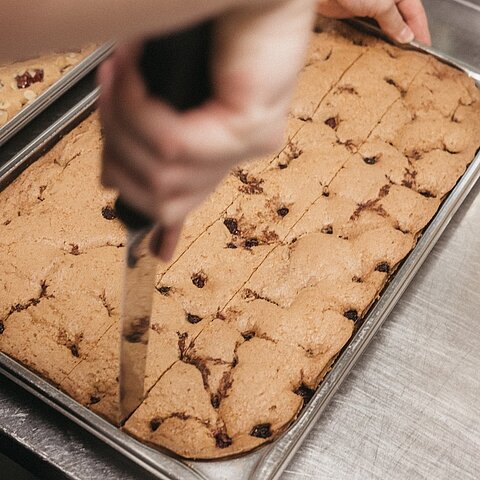 Ein Handgriff hier. Eine geschwungene Pfanne dort. Ein Lächeln, das man sogar durch den Küchendampf spürt.